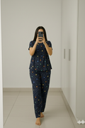 Woman wearing navy blue peplum nightwear set at home