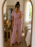 Woman wearing a premium ribbed knitted cotton pink leopard print peplum night suit with a V-neck top and matching straight-fit lounge pants by Irah Vastra.